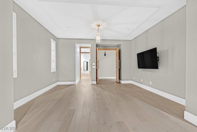 unfurnished living room featuring light wood finished floors and baseboards