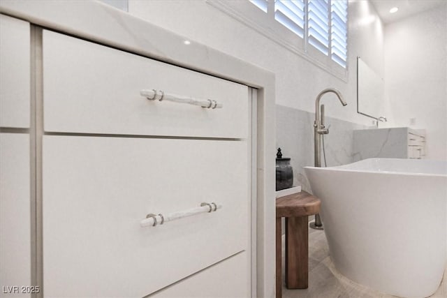 full bath with a soaking tub and a sink