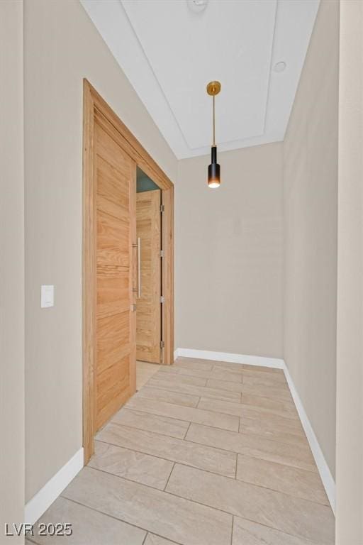 hallway featuring baseboards and wood finish floors