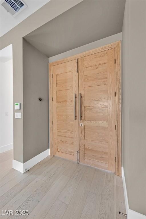 entryway with baseboards, visible vents, and wood finished floors