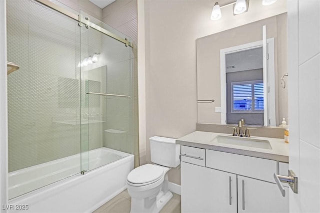 full bath featuring toilet, bath / shower combo with glass door, vanity, baseboards, and tile patterned floors