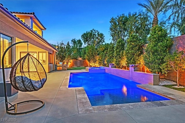 pool with an in ground hot tub, a patio, and a fenced backyard