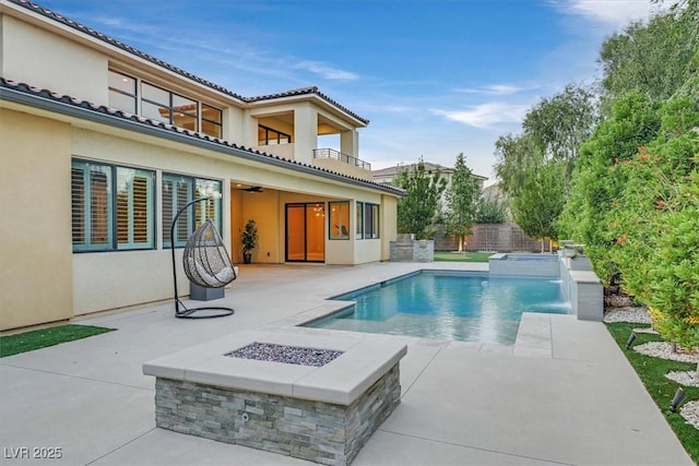 view of swimming pool featuring a fenced in pool, a ceiling fan, a patio area, fence, and a fire pit