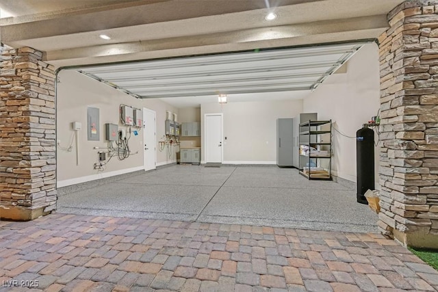 garage featuring electric panel and baseboards