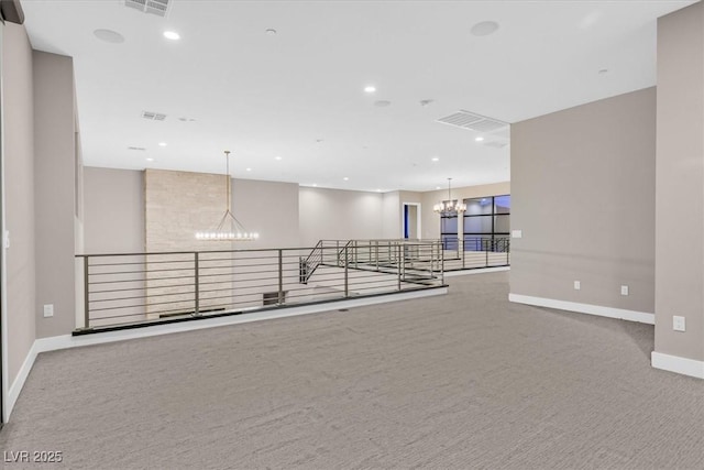 carpeted empty room with recessed lighting, visible vents, a notable chandelier, and baseboards