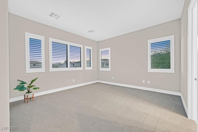 unfurnished room featuring carpet floors, visible vents, and baseboards