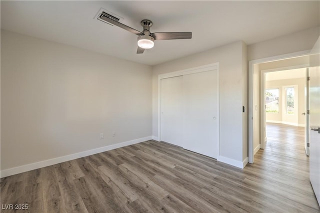 unfurnished bedroom featuring light hardwood / wood-style flooring, a closet, and ceiling fan