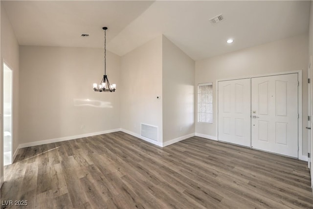 interior space with dark hardwood / wood-style flooring, vaulted ceiling, and a notable chandelier