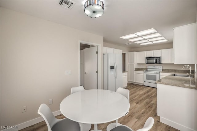 dining space with sink and light hardwood / wood-style floors