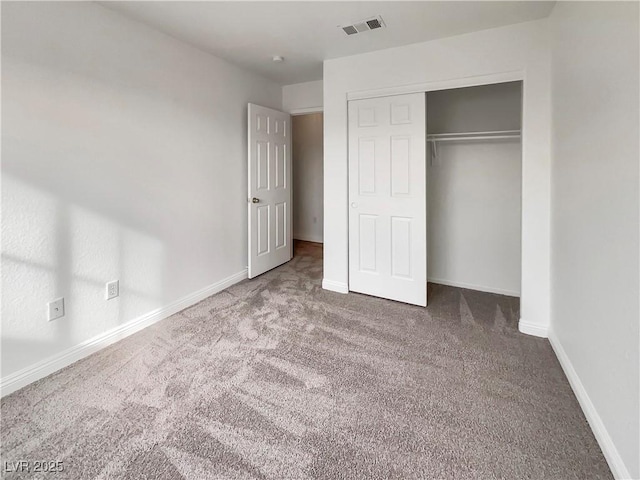 unfurnished bedroom featuring a closet, visible vents, carpet flooring, and baseboards