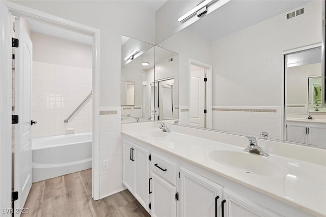 bathroom featuring tile walls, hardwood / wood-style floors, and vanity