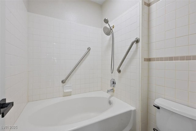 bathroom featuring toilet and tiled shower / bath