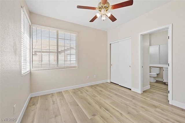 unfurnished bedroom featuring ceiling fan, connected bathroom, light hardwood / wood-style floors, and a closet