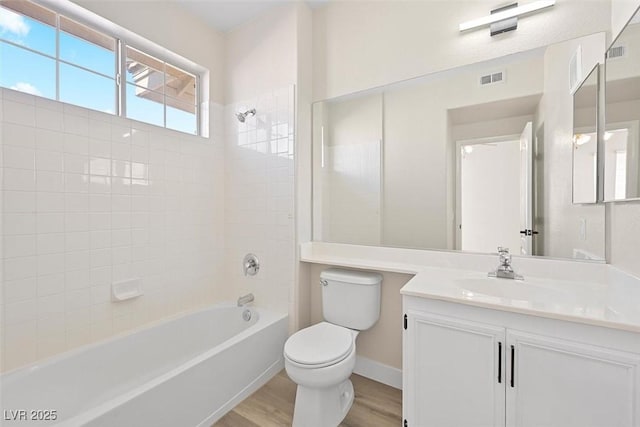 full bathroom featuring tiled shower / bath, wood-type flooring, toilet, and vanity