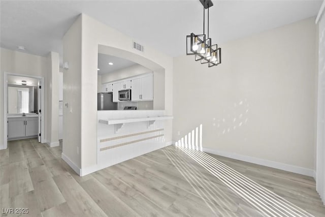 interior space featuring a chandelier and light hardwood / wood-style flooring