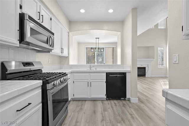 kitchen featuring white cabinetry, pendant lighting, and appliances with stainless steel finishes