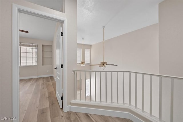 hall featuring light hardwood / wood-style flooring and a textured ceiling