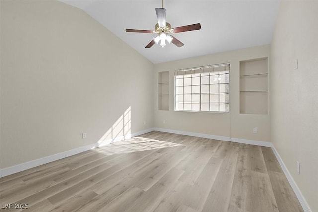 empty room featuring ceiling fan, vaulted ceiling, built in features, and light wood-type flooring