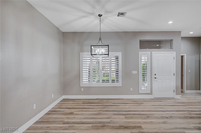 foyer with a chandelier and light wood-type flooring