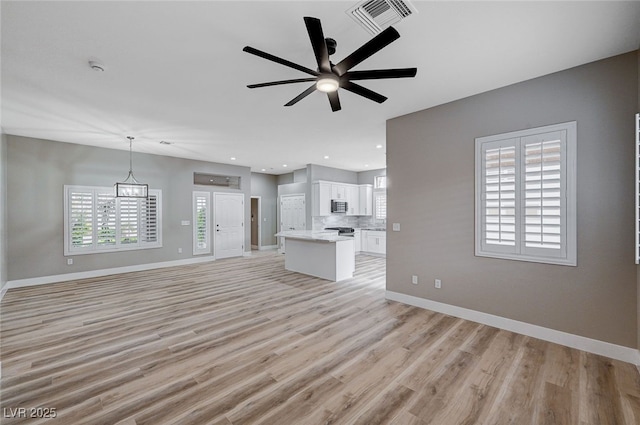 unfurnished living room with ceiling fan and light hardwood / wood-style floors