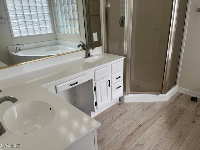 bathroom with vanity, independent shower and bath, and hardwood / wood-style floors