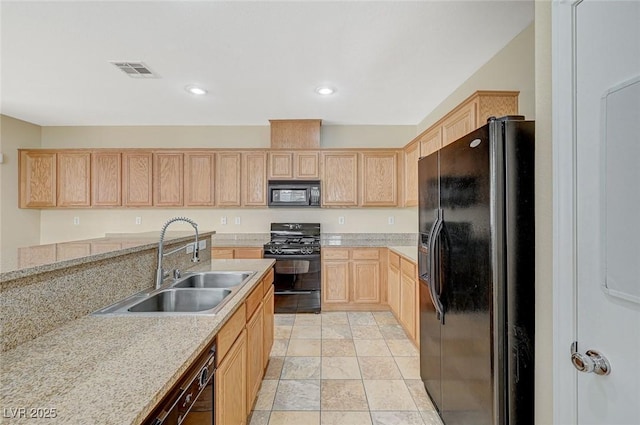 kitchen featuring light stone countertops, sink, light brown cabinets, and black appliances