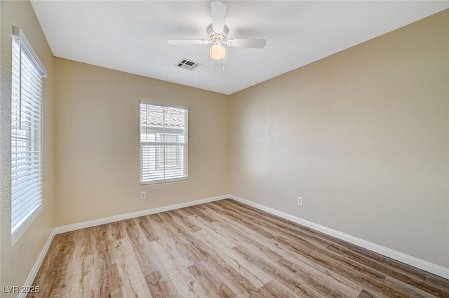 empty room with ceiling fan and light hardwood / wood-style floors