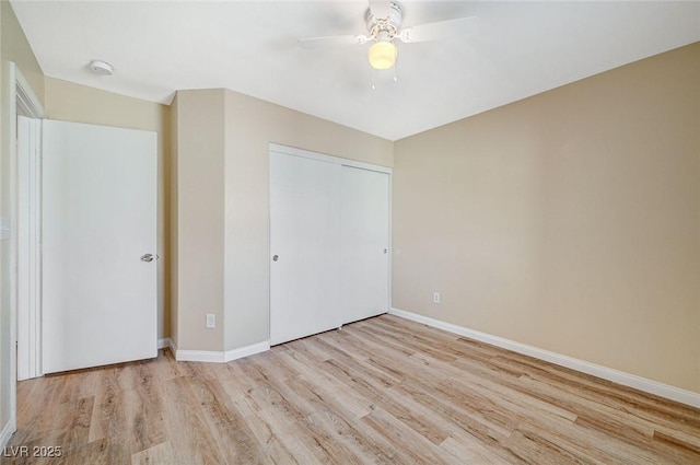 unfurnished bedroom featuring ceiling fan, a closet, and light hardwood / wood-style flooring