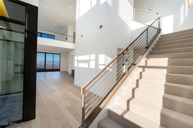 stairs featuring hardwood / wood-style flooring and a wall of windows