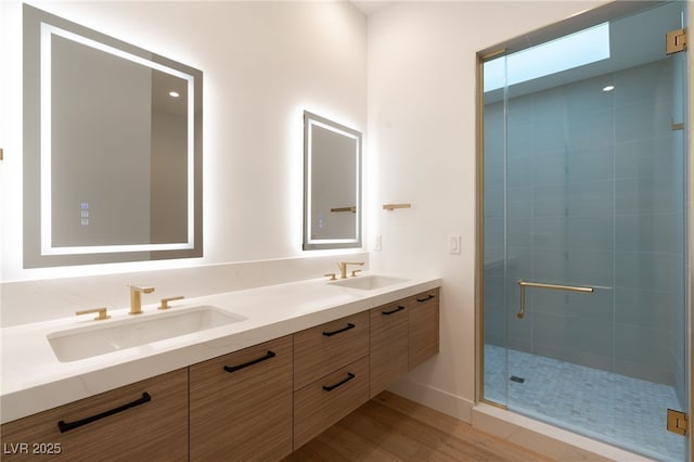 bathroom with vanity, hardwood / wood-style flooring, and a shower with shower door