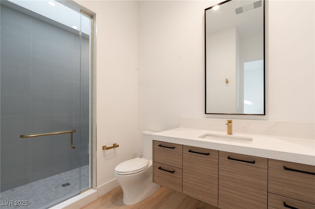 bathroom with vanity, hardwood / wood-style floors, a shower with door, and toilet