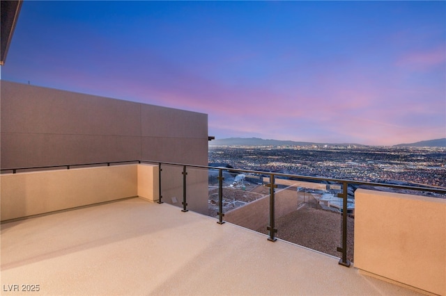 balcony at dusk featuring a mountain view