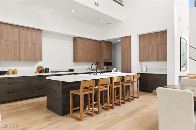 kitchen with modern cabinets, visible vents, a kitchen breakfast bar, and light countertops