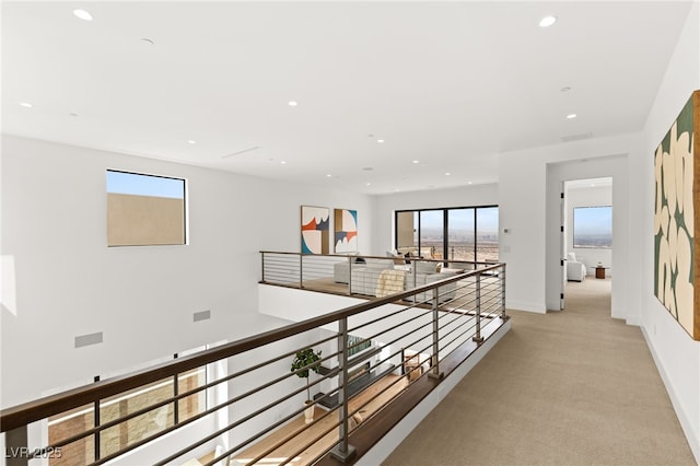 corridor featuring visible vents, baseboards, light colored carpet, an upstairs landing, and recessed lighting