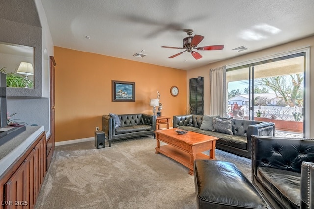 living room with a textured ceiling, light colored carpet, and ceiling fan