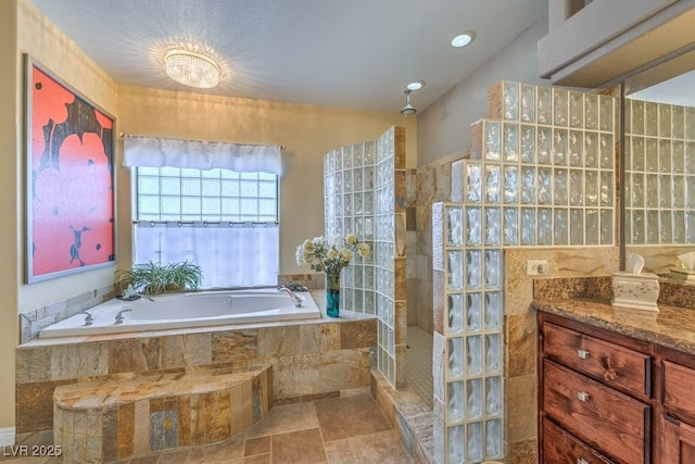 bathroom featuring vanity and independent shower and bath