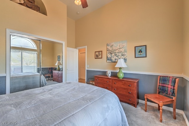 bedroom featuring ceiling fan, carpet flooring, a closet, and a high ceiling