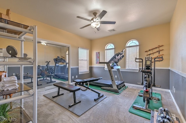 exercise area featuring ceiling fan and carpet flooring