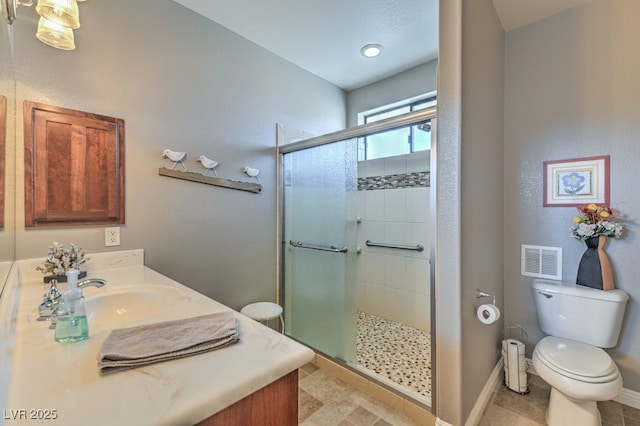 bathroom with walk in shower, vanity, and toilet