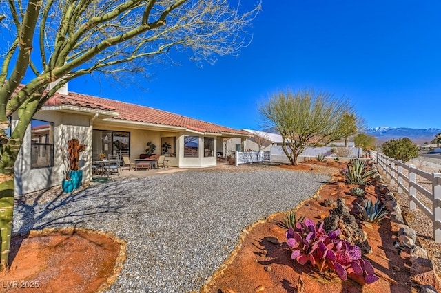 rear view of property with a mountain view and a patio