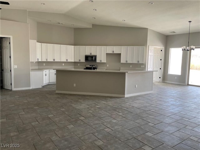 kitchen featuring pendant lighting, white cabinetry, a kitchen island with sink, an inviting chandelier, and high vaulted ceiling