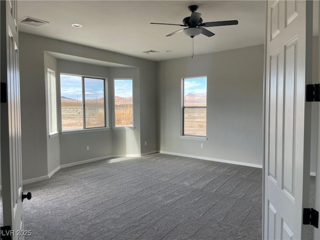 empty room featuring ceiling fan, carpet flooring, and a mountain view