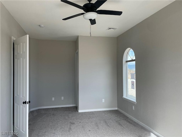 carpeted spare room with ceiling fan