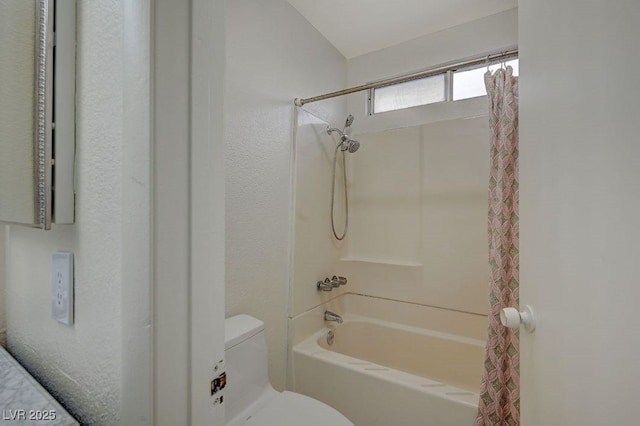 bathroom featuring toilet and shower / bath combo