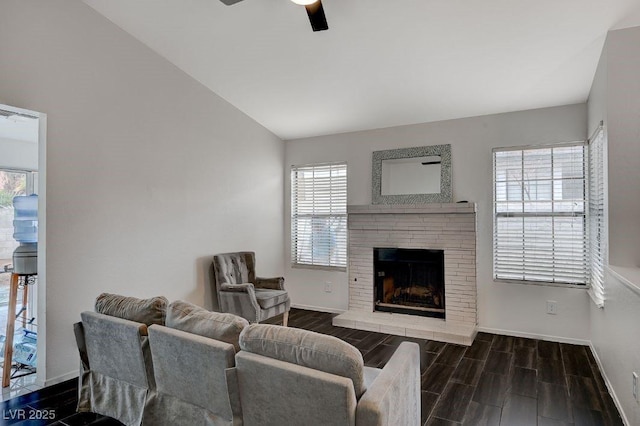 living room featuring a fireplace, vaulted ceiling, and ceiling fan