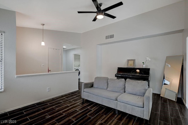 living room featuring ceiling fan, lofted ceiling, and washer / dryer