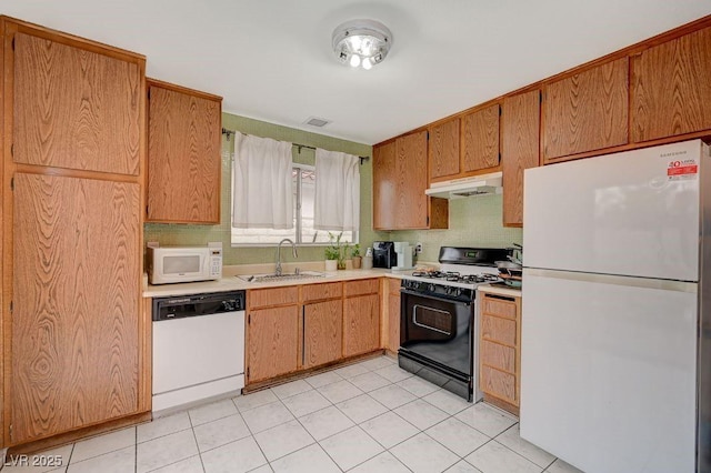 kitchen featuring tasteful backsplash, light tile patterned flooring, sink, and white appliances