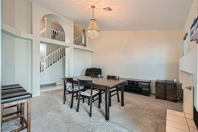 carpeted dining area with a towering ceiling