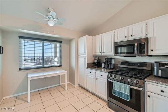 kitchen featuring light tile patterned flooring, lofted ceiling, white cabinets, ceiling fan, and stainless steel appliances