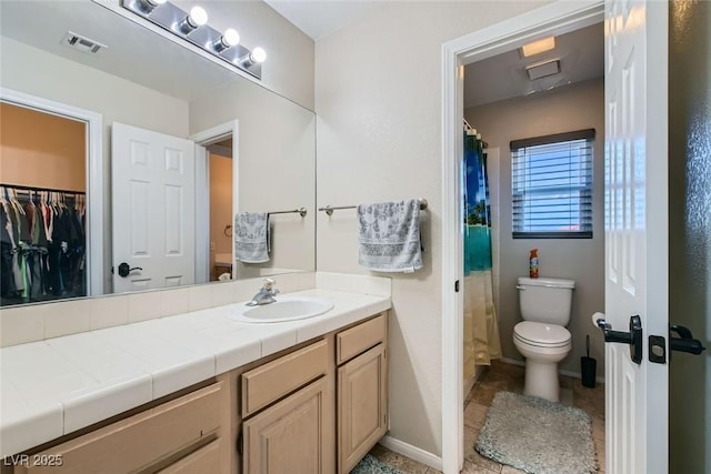 bathroom featuring tile patterned flooring, vanity, and toilet